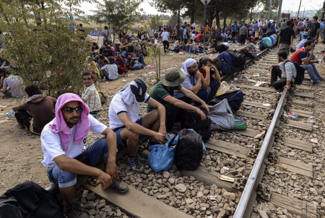 Inmigrantes esperan para cruzar desde Grecia a la ciudad de Gevgelija,...