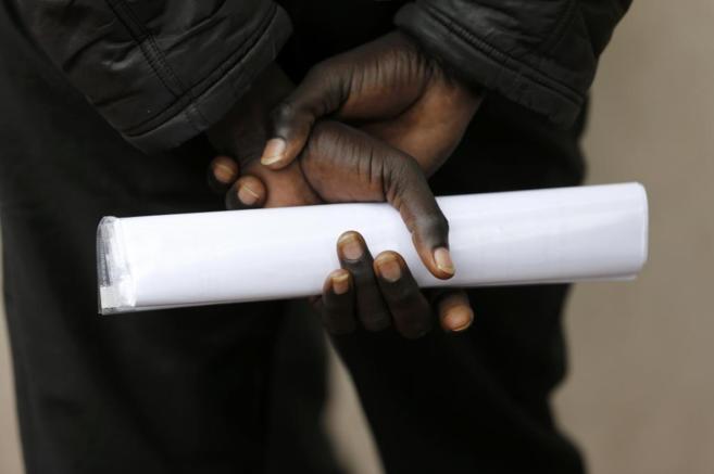 Un inmigrante sujeta los documentos para pedir asilo en Calais.