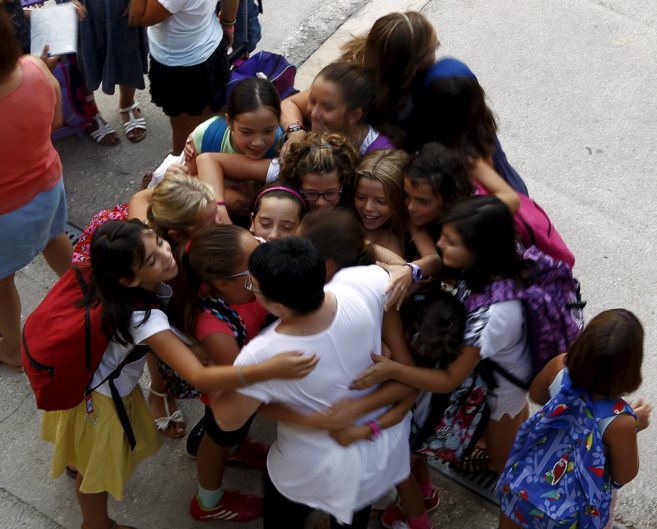 Varios alumnos abrazan a su profesora el primer da de colegio.