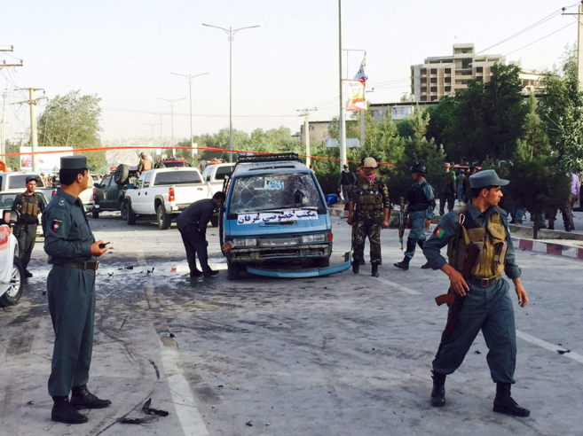 Agentes de seguridad afganos inspeccionan el coche bomba que estall,...