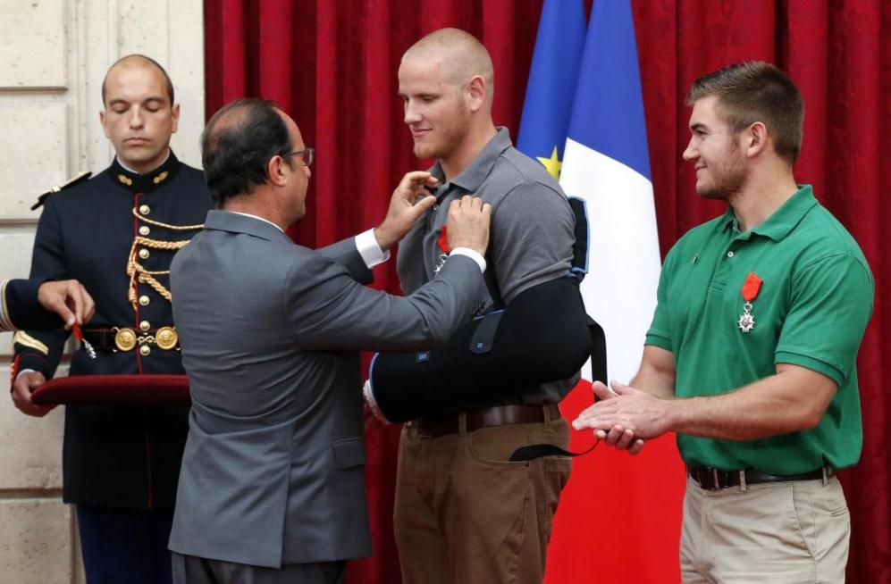 El presidente francs, Franois Hollande, pone la medalla a Spencer...