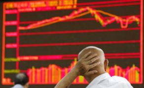 Un inversor mira un panel de la Bolsa china.
