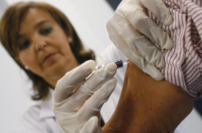 Una enfermera aplica una vacuna contra la gripe.