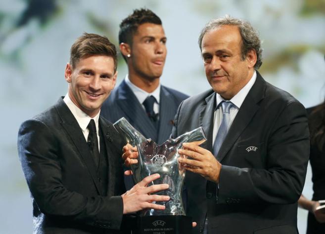 Messi recibe el trofeo en manos de Michel Platini, presidente de la...
