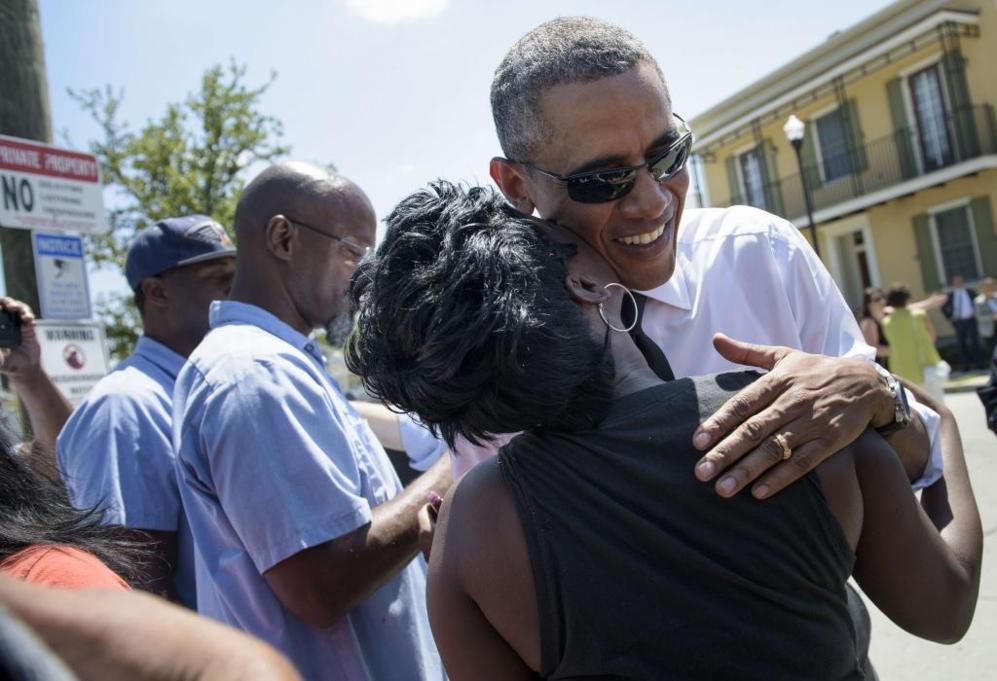 Una mujer besa a un sonriente Obama durante su visita a Nueva Orleans.