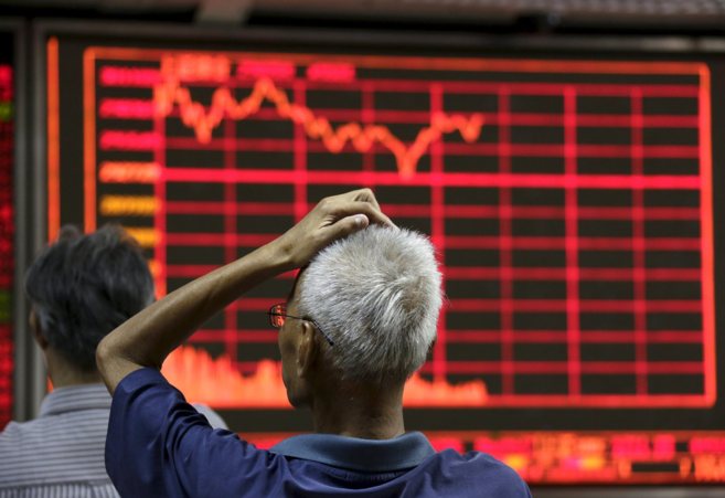 Un inversor chino mira ayer las cotizaciones de los mercados en la...