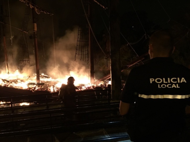 Policas locales y bomberos durante la extincin de las llamas en...