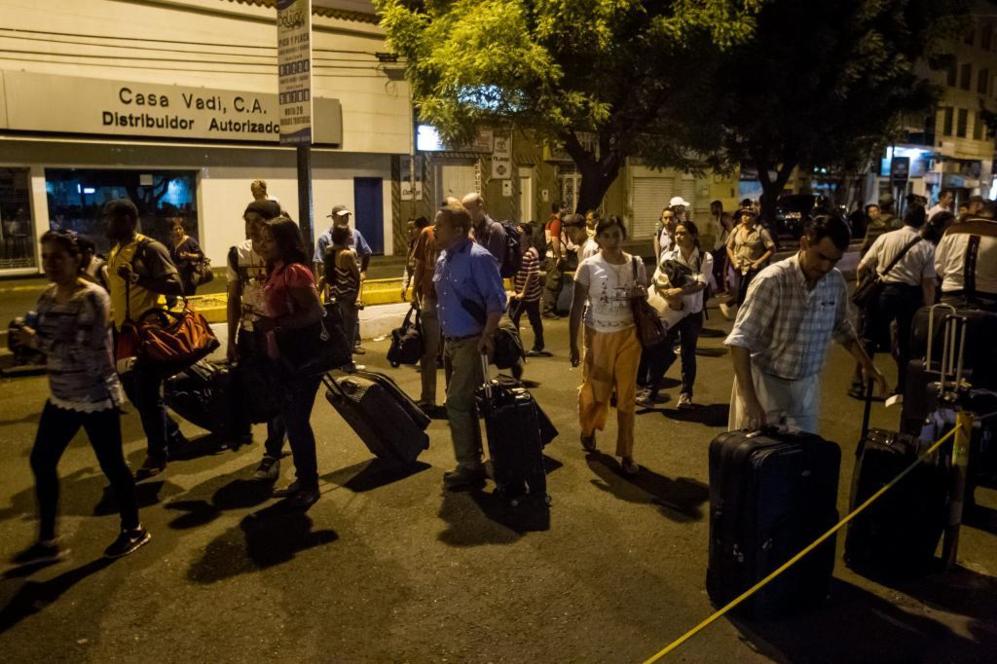 Un grupo de personas que solicita la salida de Venezuela hacia...