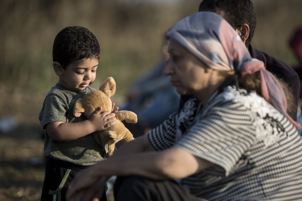 Un nio refugiado juega con un peluche junto a su familia, en Roszke,...