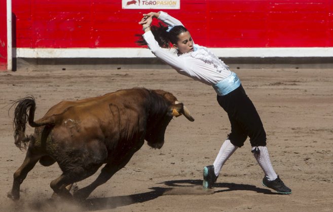 Una de las participantes en el duelo recorta al toro.