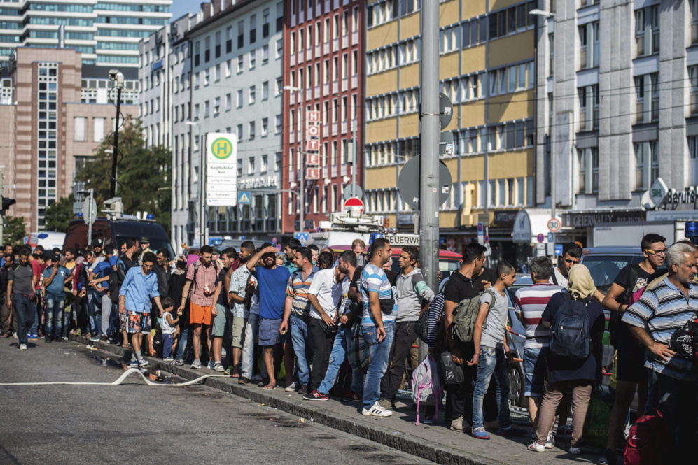 Refugiados procedentes de Budapest esperan un medio de transporte para...