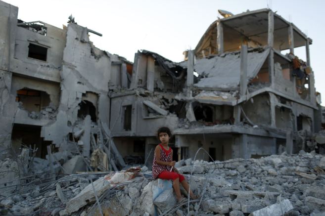 Una nia palestina juega entre las ruinas de una casa destruida...