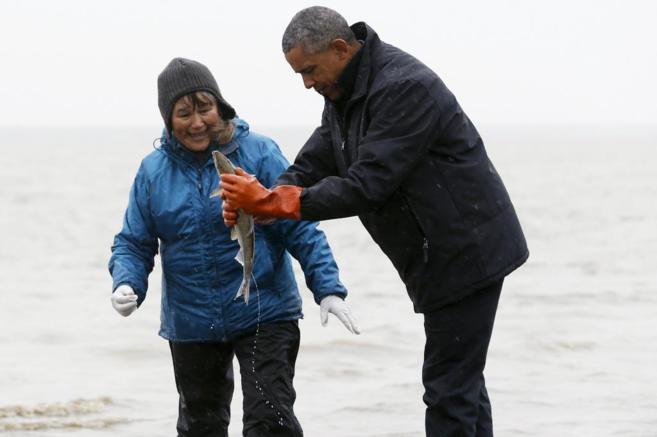 Obama intenta sujetar a un pez durante el encuentro con un pescador en...