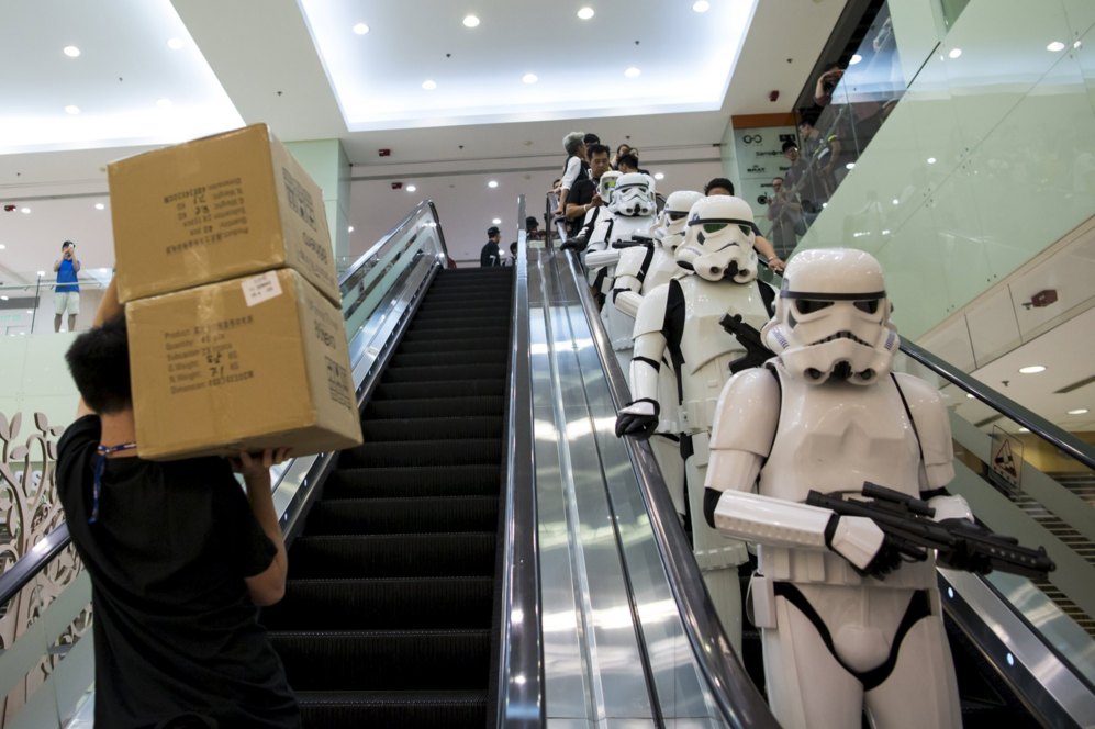 Un hombre, con cajas con 'merchandising' de 'Star Wars' pasa junto a...