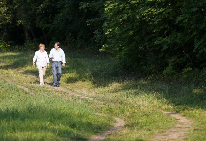 Rajoy pasea junto a Merkel en los alrededores de lago de Scholss