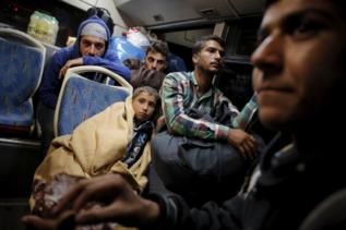 Varios refugiados en los autobuses del traslado.  A. DI LOLLI