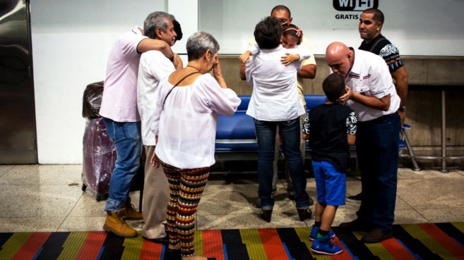 Una familia venezolana, desconsolada, durante una despedida en el...