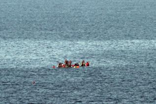 Un grupo de refugiados intenta mantenerse a flote en su bote cerca de...
