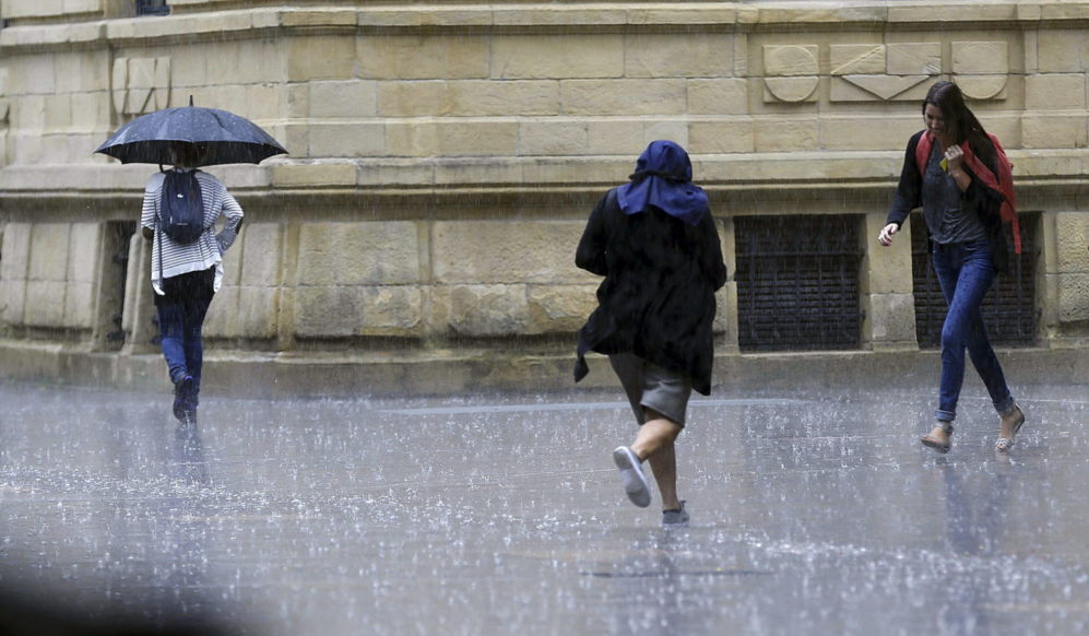 Varias personas sorprendidas por la lluvia en San Sebastíán.