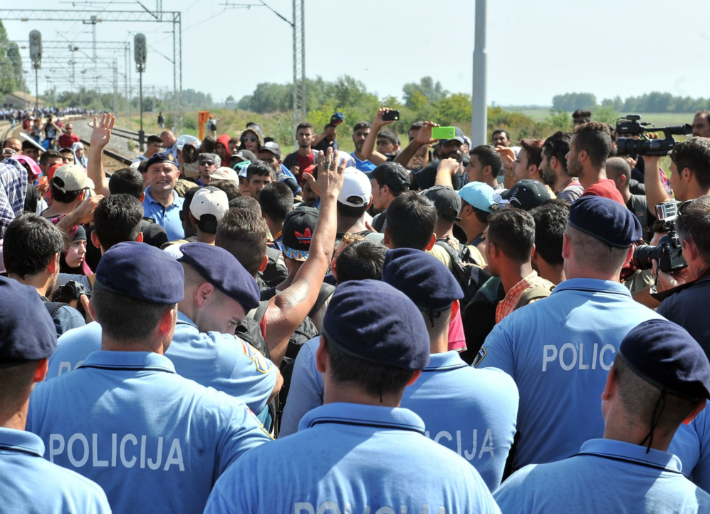 Agentes de policía croatas evitan que los migrantes salgan a pie de...