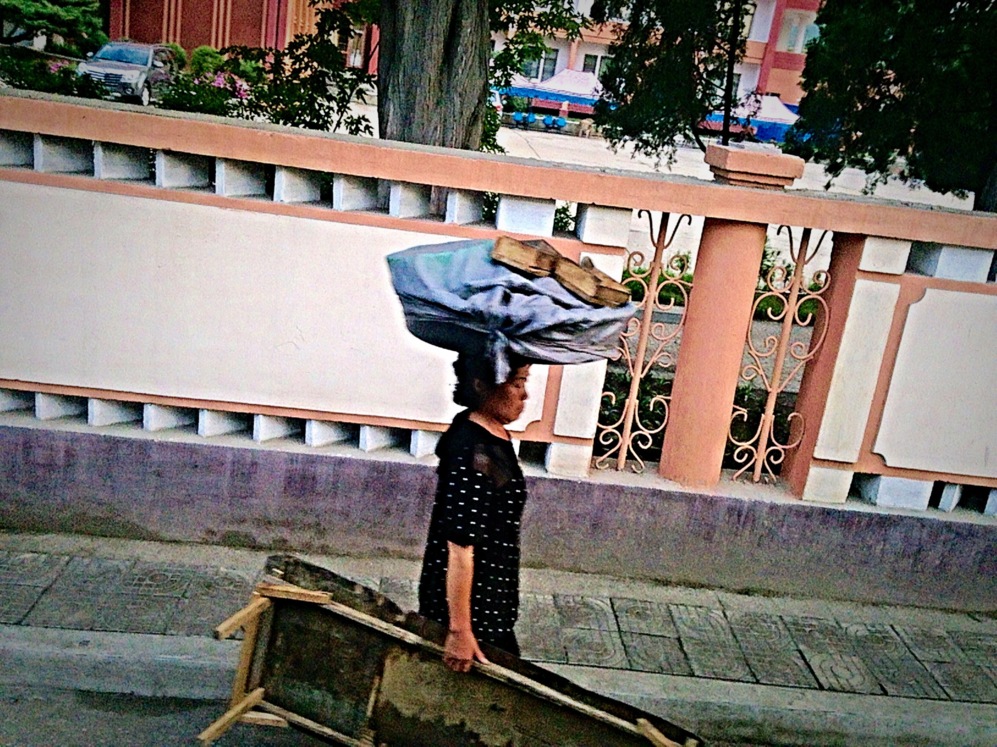 Una mujer transporta materiales de construcción en Pyongsong.