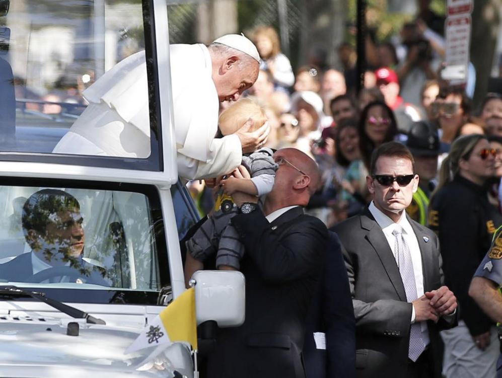 El Papa Francisco besa la cabeza de un nio, durante el recorrido por...