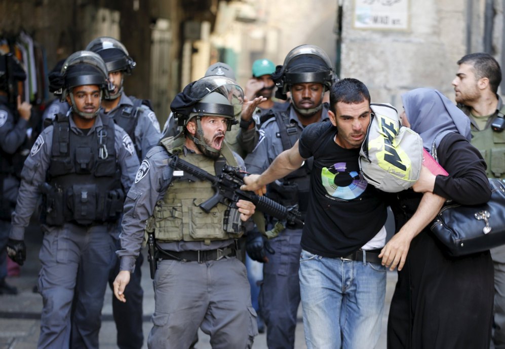 Un polica israel impide a un hombre palestino entrar en el recinto...