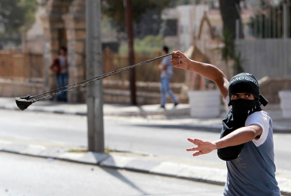 Un joven palestino lanza una piedra durante los enfrentamientos contra...