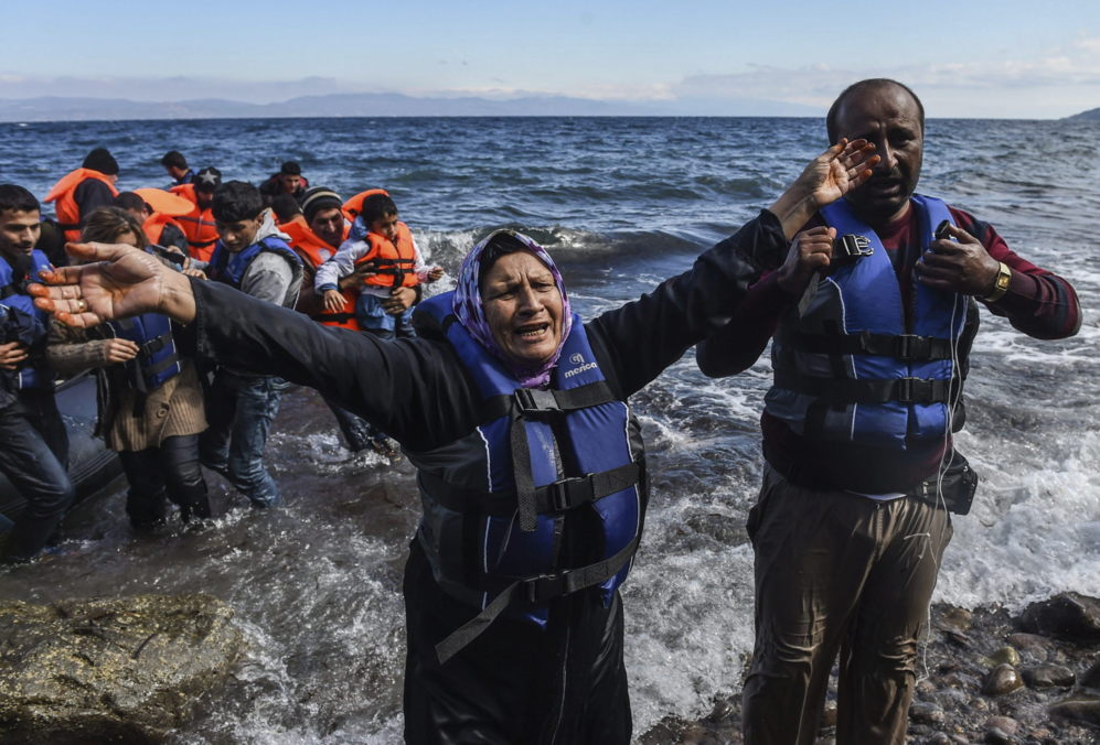 Una refugiada afgana emocionada tras alcanzar la costa a bordo de una...