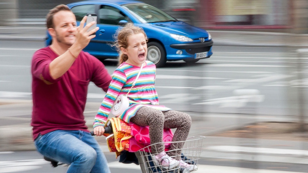 Un hombre en bicicleta con su hija se hace un &apos;selfie&apos;