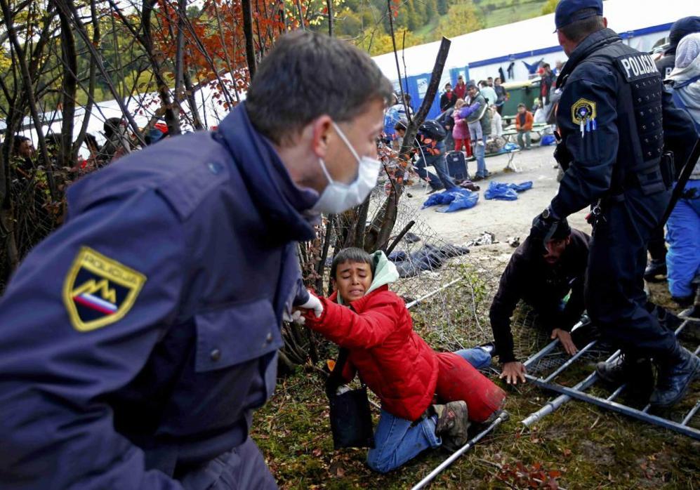 Un polica esloveno salva a un chico tras la multitud de refugiados...