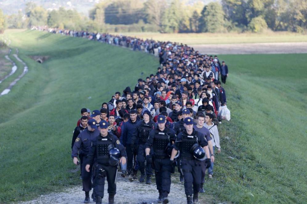 Los refugiados son escoltados por la polica eslovena en su camino...