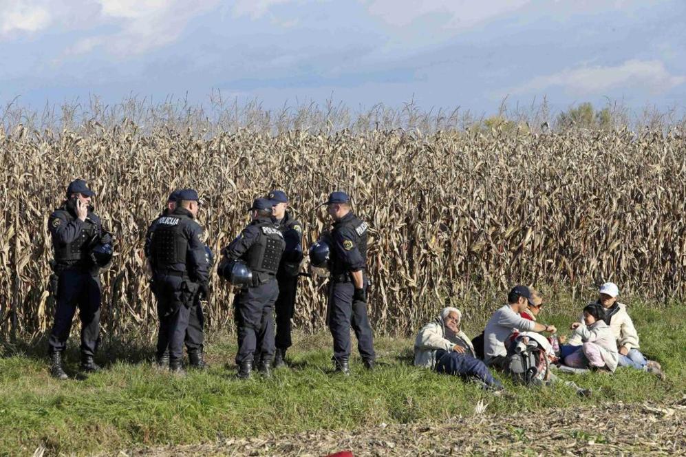 Fuerzas de seguridad eslovenas vigilan a los refugiados mientras...