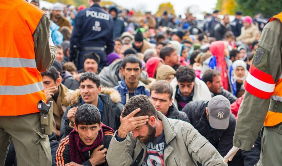Inmigrantes y refugiados esperan a coger un autobs para cruzar la...