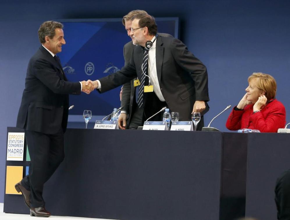 Rajoy y Sarkozy se estrechan la mano durante la clausura del congreso...