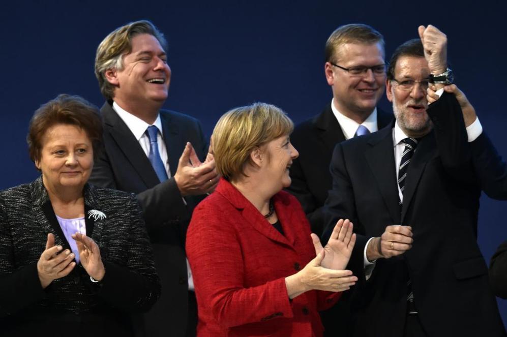 Rajoy, en otro momento de la clausura, junto a Merkel y la primera...