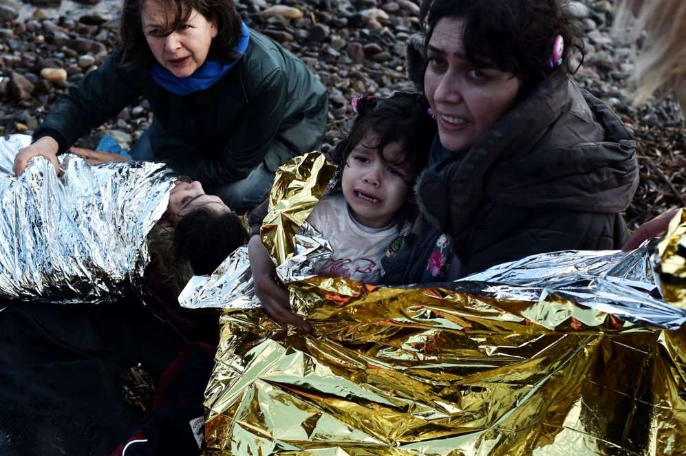 Una mujer con su hija, envuelta en una manta trmica, lloran tras...