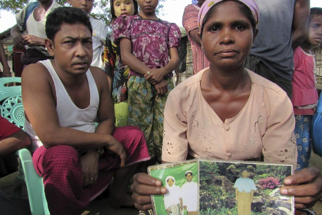 Una mujer rohingya ensea la foto de sus familiares desaparecidos.