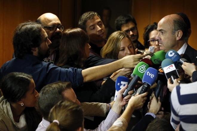 El ministro de Economa, Luis de Guindos, rodeado de micrfonos de...