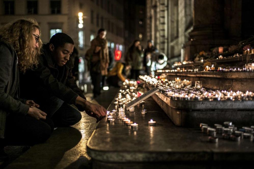 En Lyon, varias personas encienden velas rindiendo tributo a las...