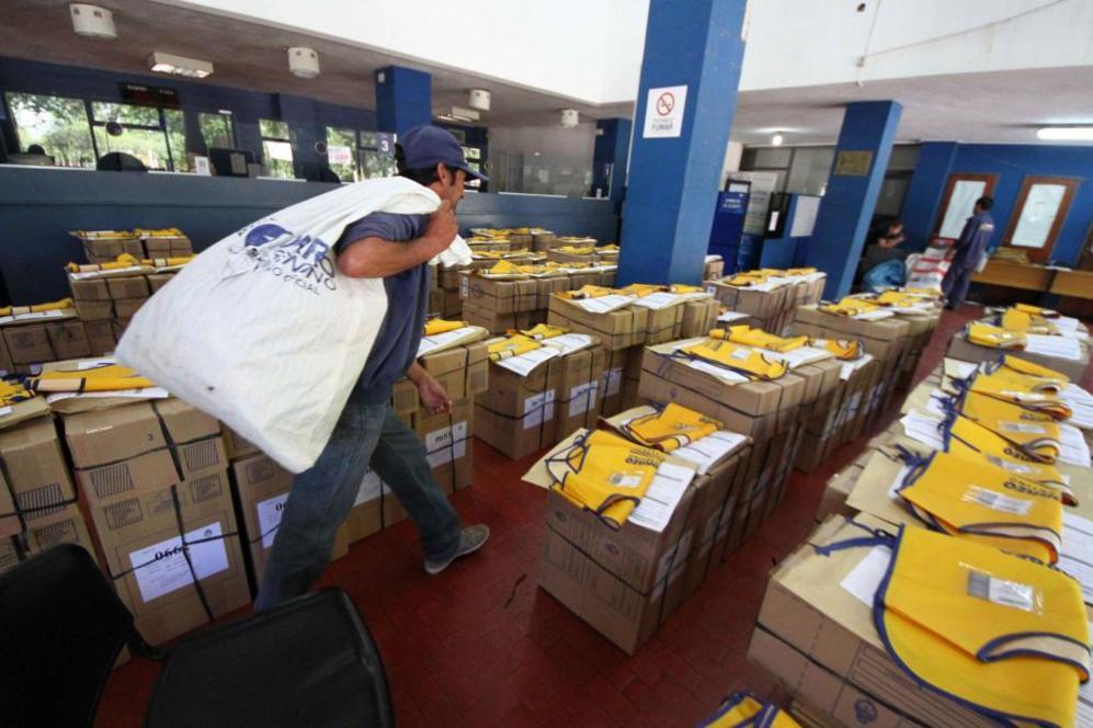 Un empleado de Correos carga urnas electorales para ser repartidas en...