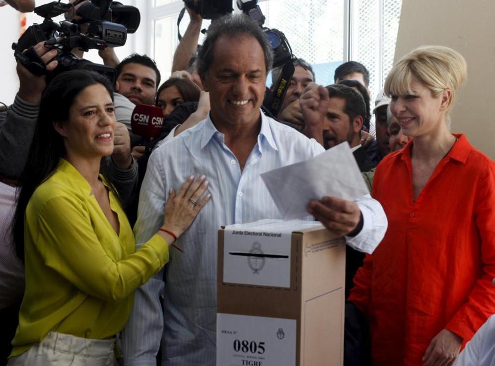 Daniel Scioli votando acompaada de su mujer y su hija en un centro...