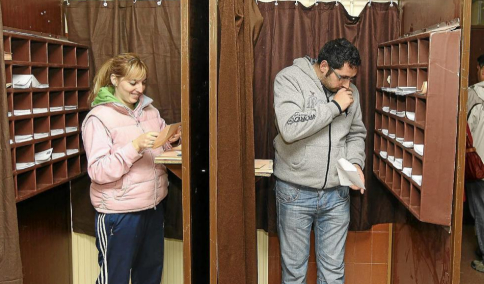 Dos votantes dentro de las cabinas de un colegio durante las...