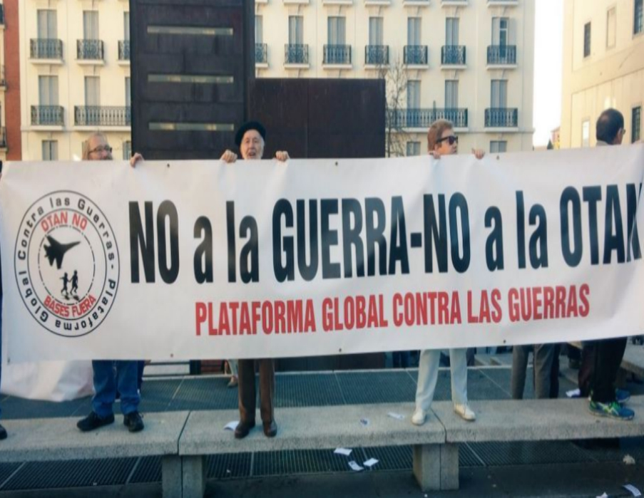 Varias personas sostienen una pancarta que dice "No a la guerra- No a...