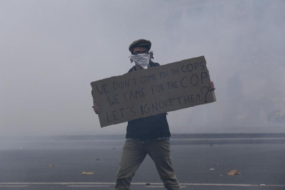 Un manifestante levanta una pancarta mientras la policía desalojaba...