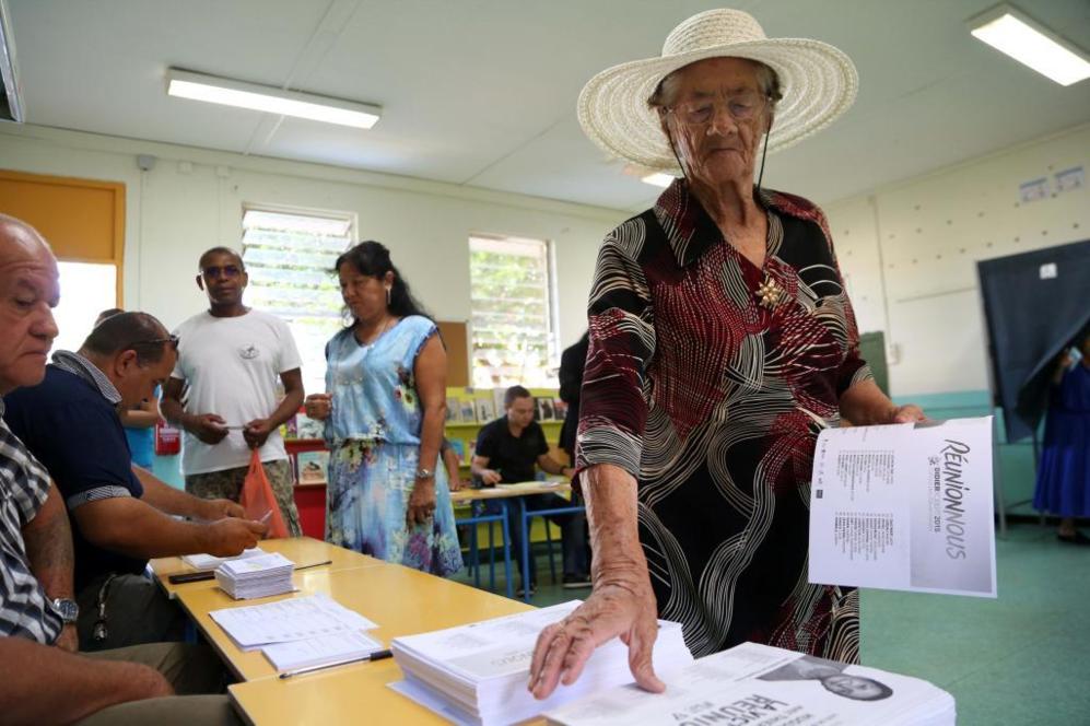 Una mujer escoge su voto en un centro electoral de Islas Reunin.