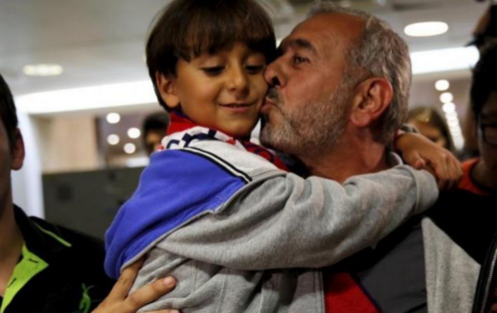 Osama, el refugiado de la zancadilla, da un beso a su hijo pequeo, a...