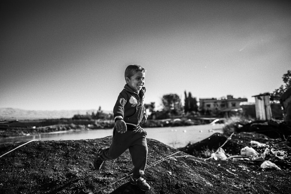 Un nio corre y juega por las calles del campo de Al Nahar, Budai