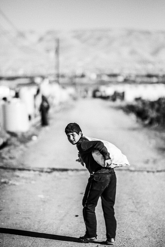 Un nio carga con un saco por el campo de  Al Nahar, el Lbano