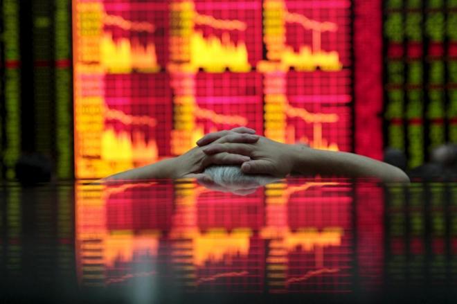 Un inversor contempla un panel bursátil en Shanghai